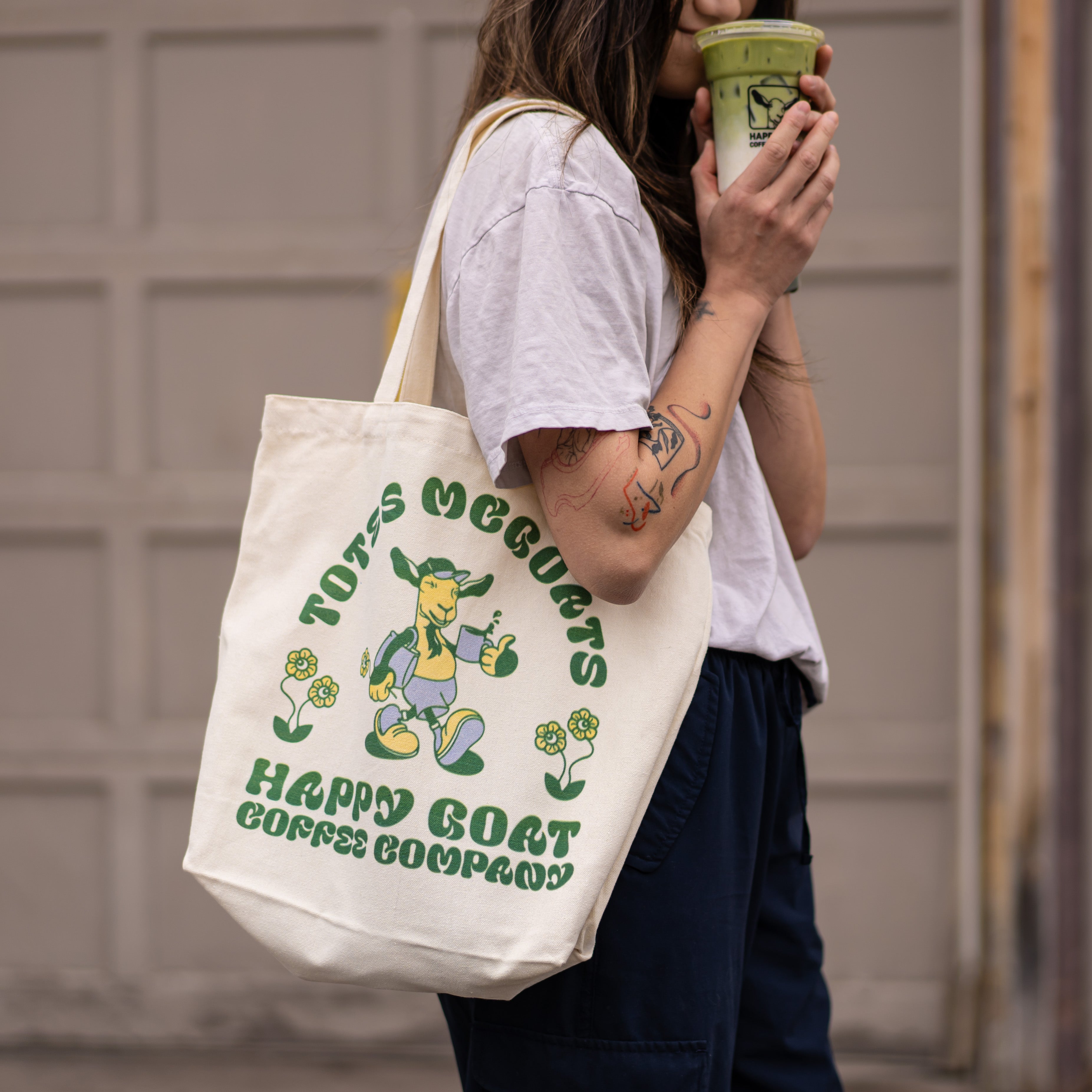 Happy Goat Coffee Tote Bag, featuring a matcha drink and model