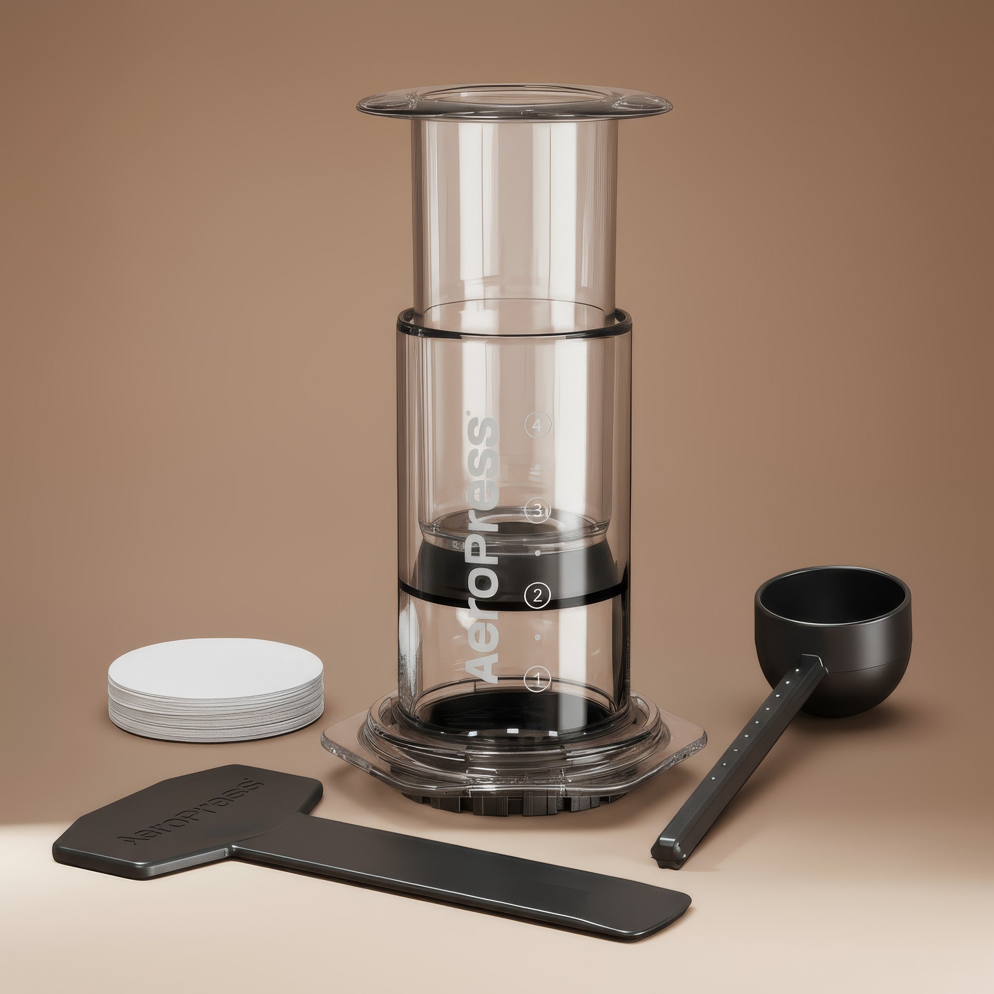 AeroPress coffee maker with components on a beige background