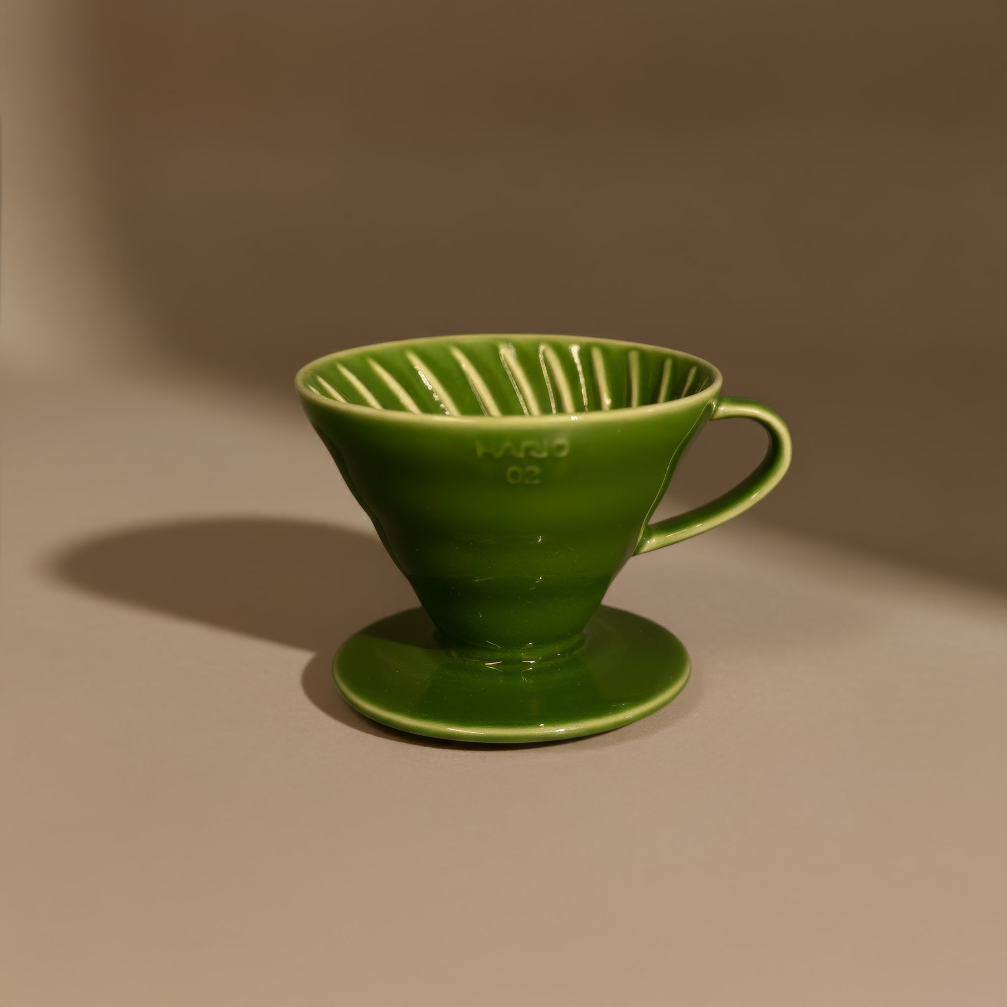 Green ceramic hario v60 coffee filter on a brown background