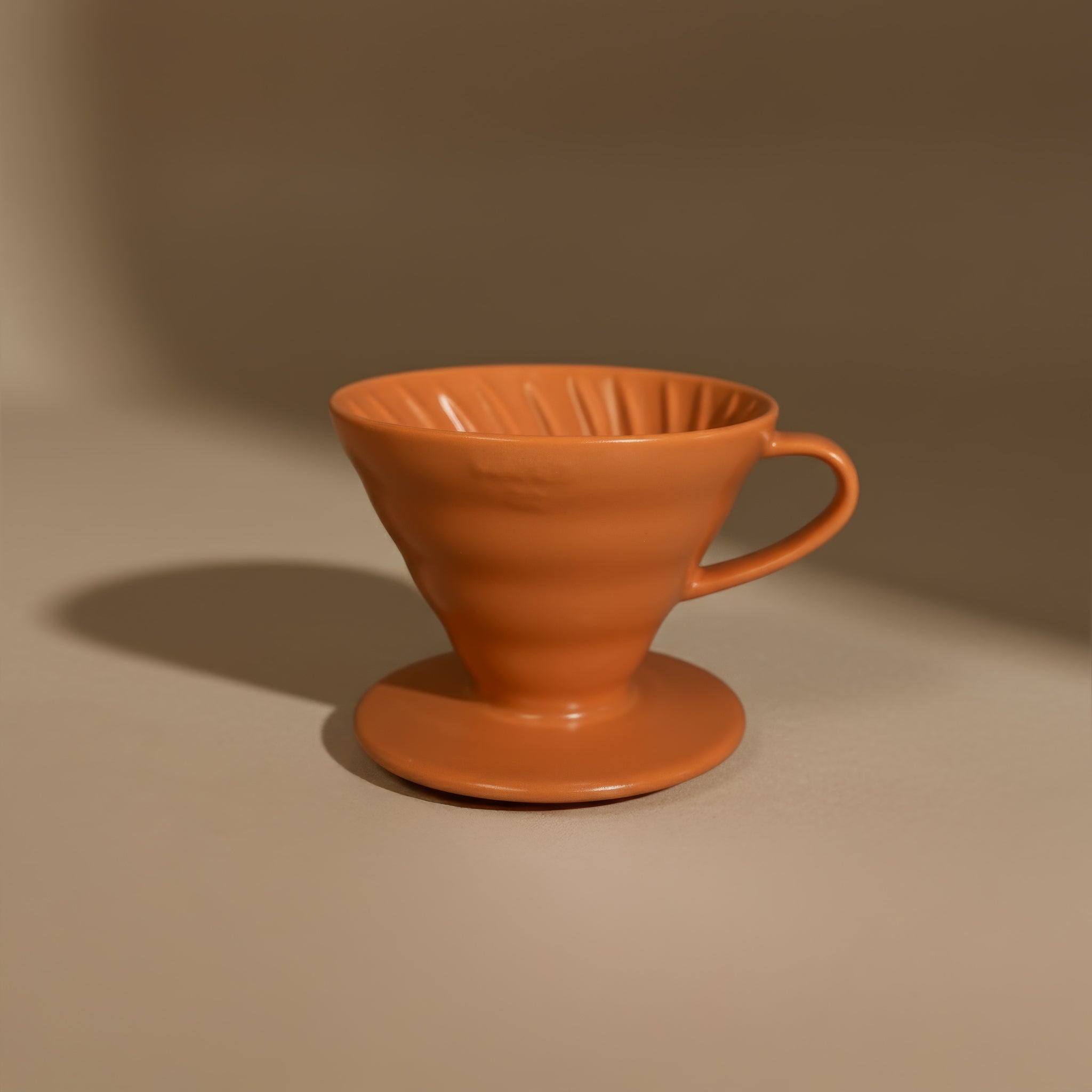 orange ceramic hario v60 coffee filter on a brown background