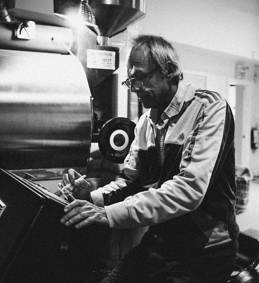 Dr. Hans operating a coffee roasting machine in a roastery.