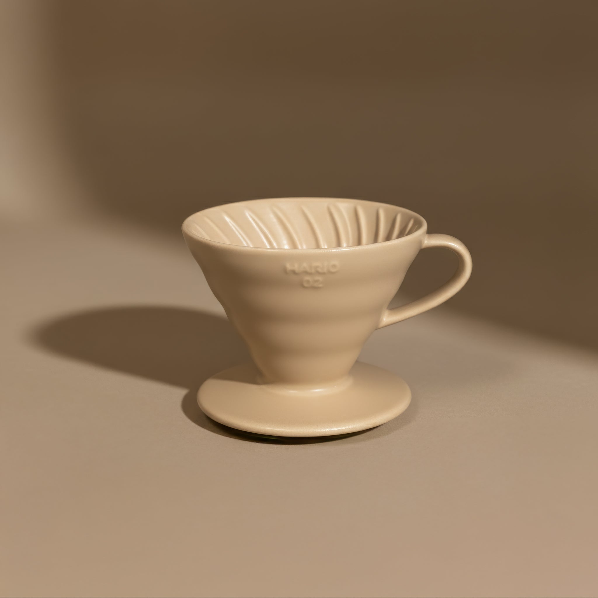 Beige ceramic hario v60 coffee filter on a brown background