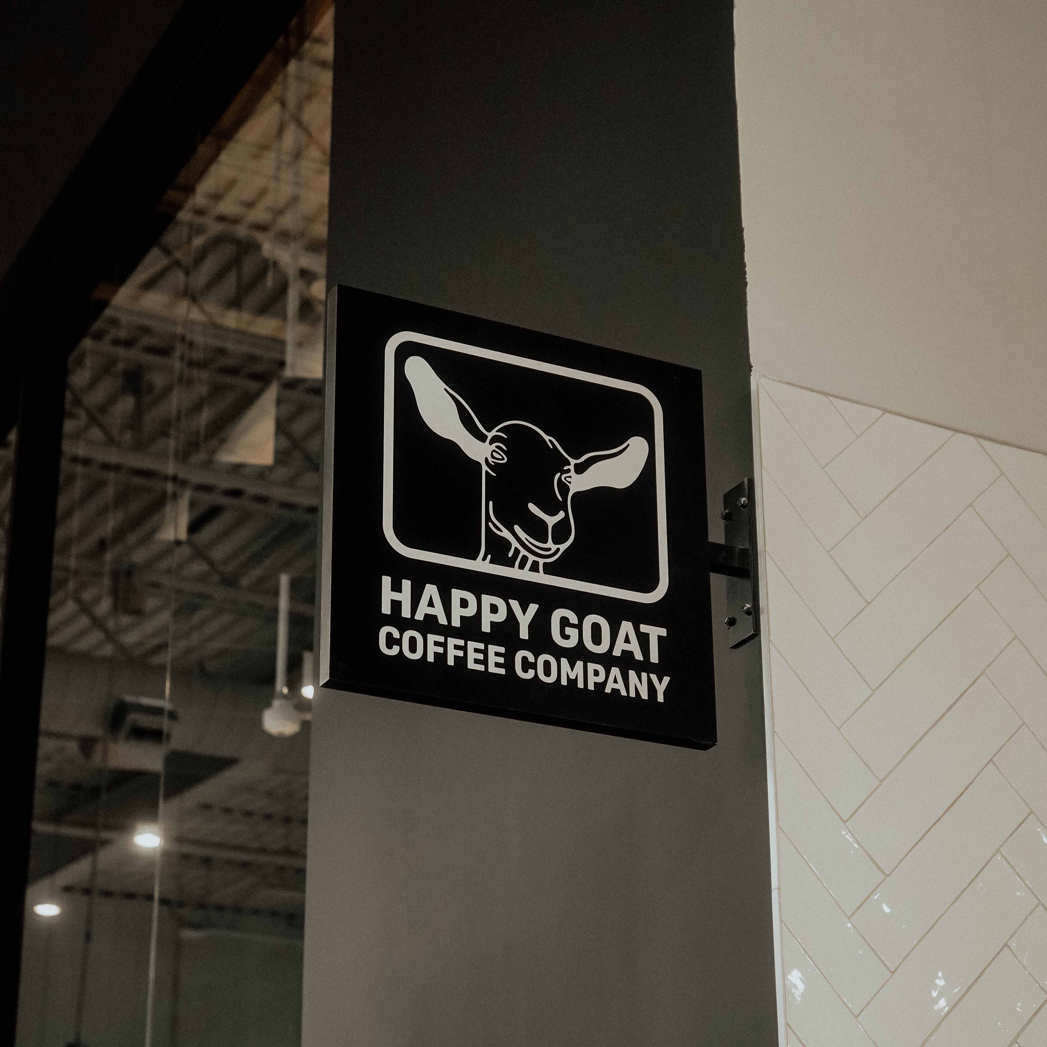 Happy Goat Coffee Company sign on a wall inside a building